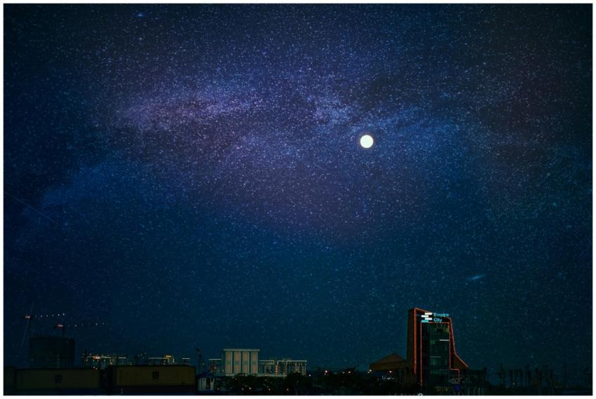 Vibrant city skyline beneath a starry night sky wi