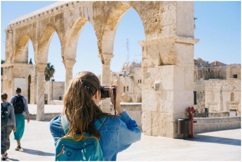 A tourist photographs the ancient stone arches in