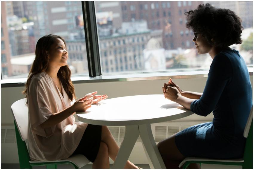 Two professional women having a discussion at a de