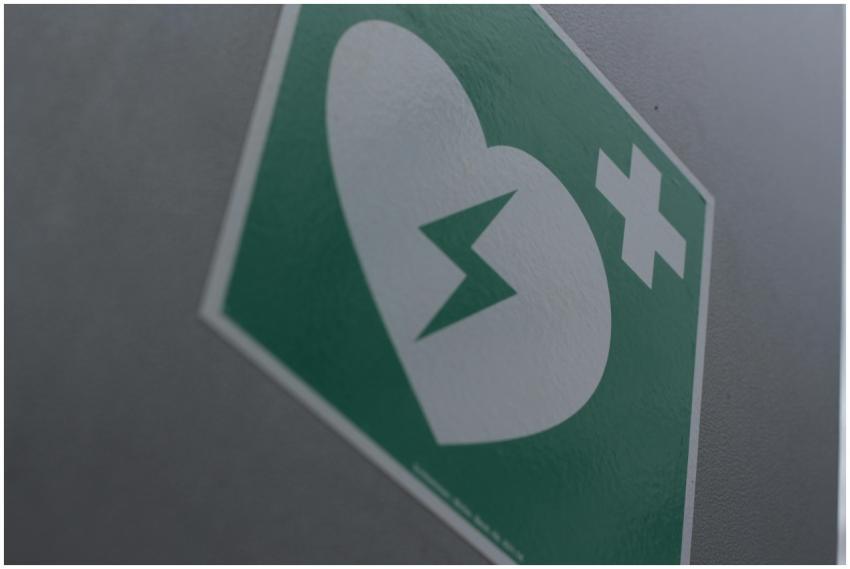 Green first aid sign featuring a broken heart and