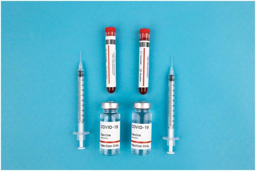 Flat lay of COVID-19 vaccine vials, syringes, and