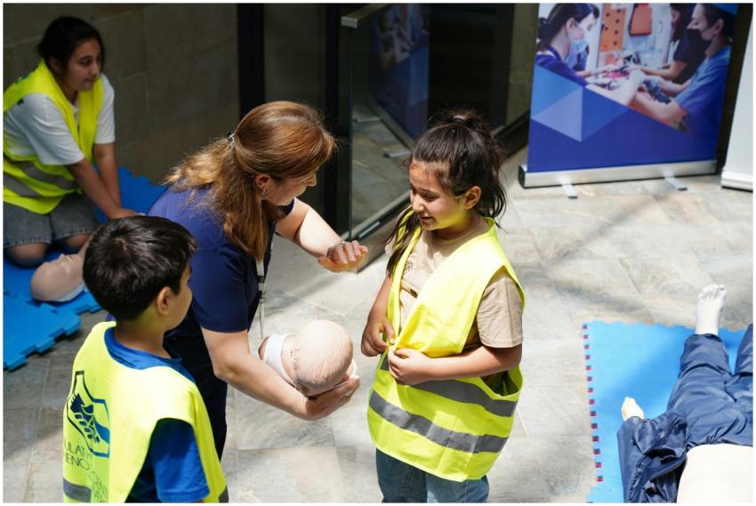 Kids and instructor learning CPR techniques during