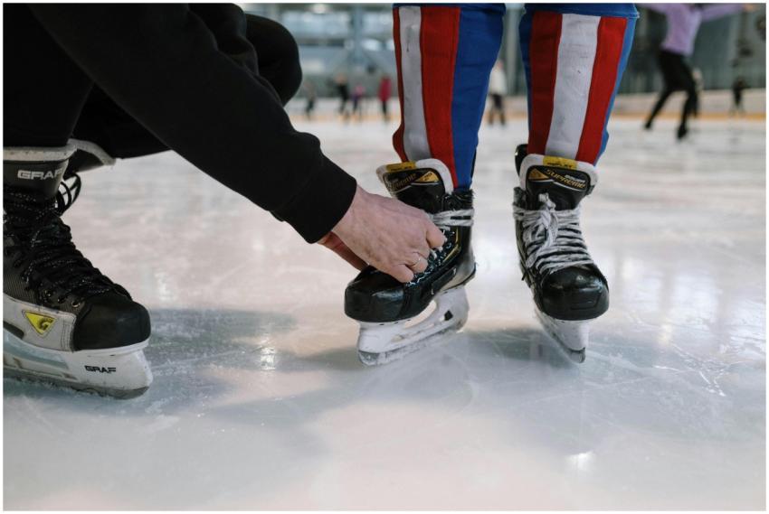 A child getting help tying ice skate laces at a sk