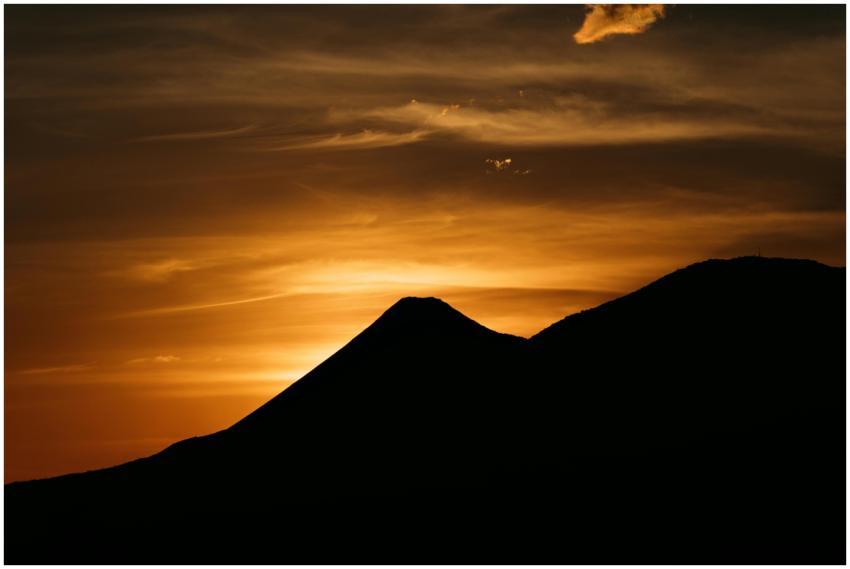 A breathtaking sunset silhouette of a volcano in E