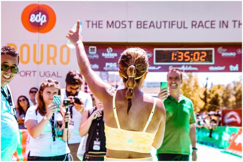 Runner celebrates at marathon finish line, surroun