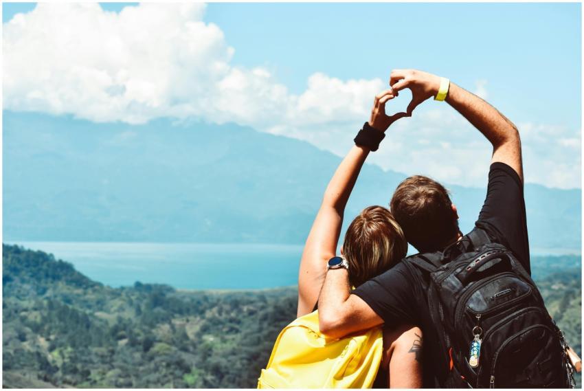 Couple making a heart shape with arms over a beaut