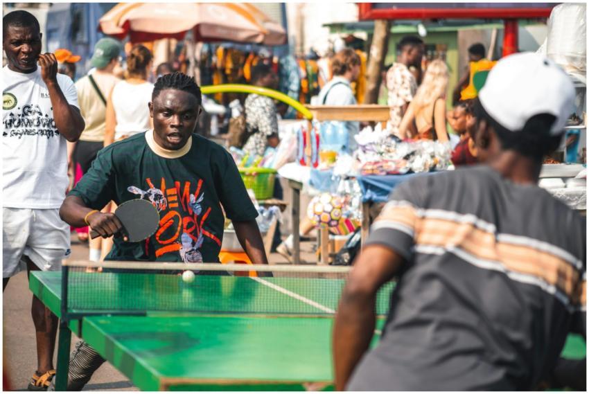 Two men enjoying a table tennis game in the street