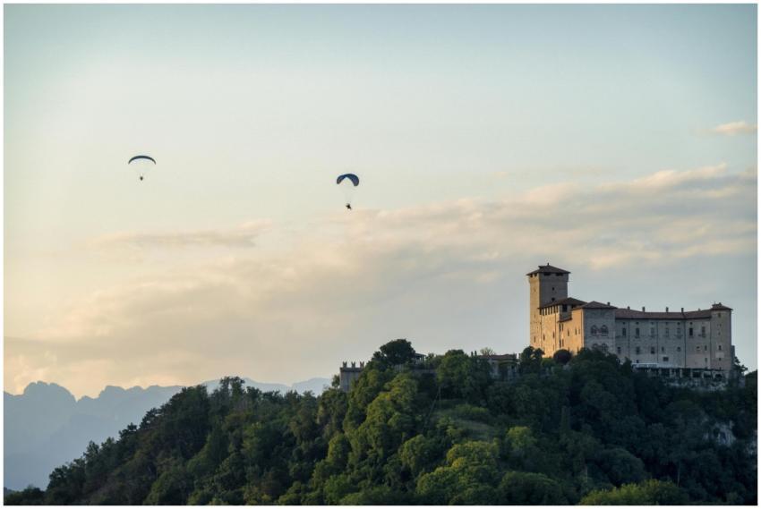 Paragliders flying over a scenic hilltop castle in