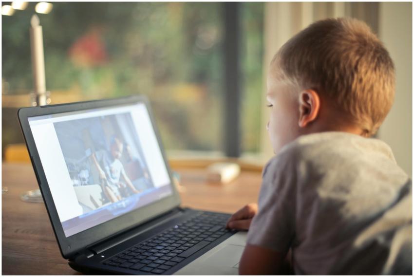 A young boy engrossed in watching content on a lap