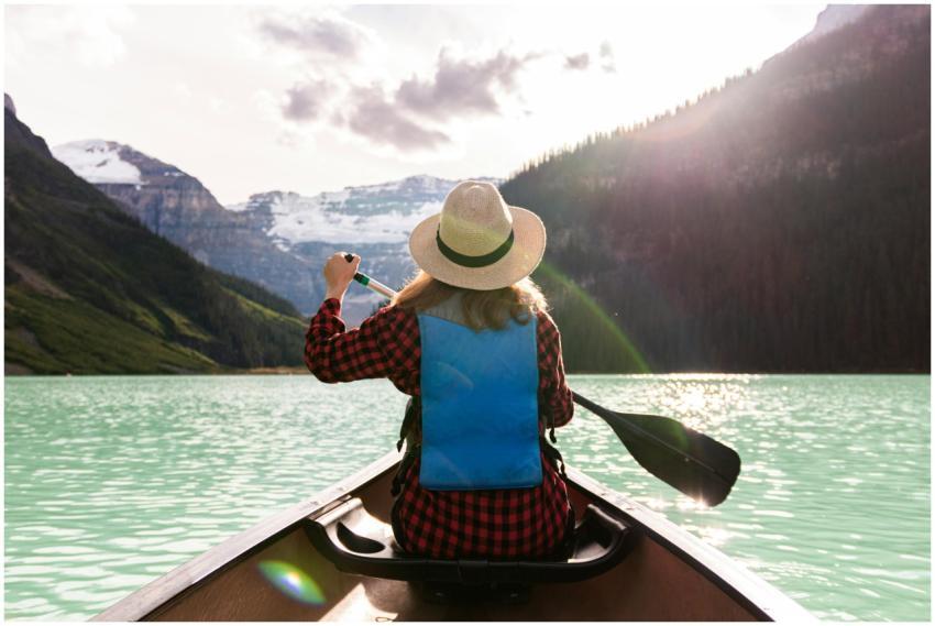 Woman paddles canoe in Lake Louise, enjoying a pea
