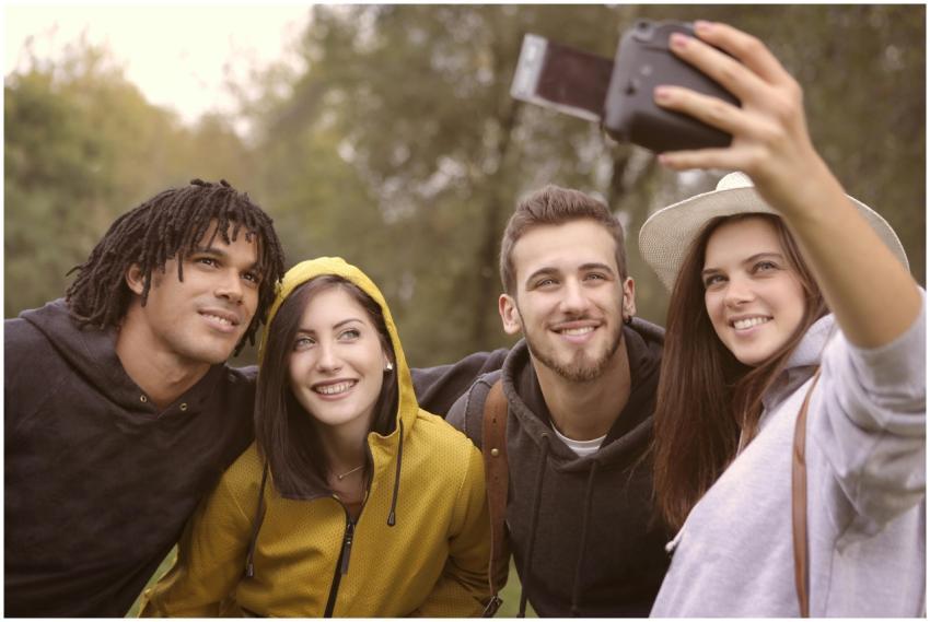 Group of young friends taking a selfie outdoors, c