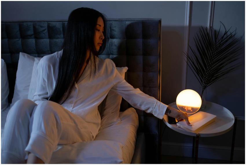 Asian woman in pajamas adjusting a glowing spheric