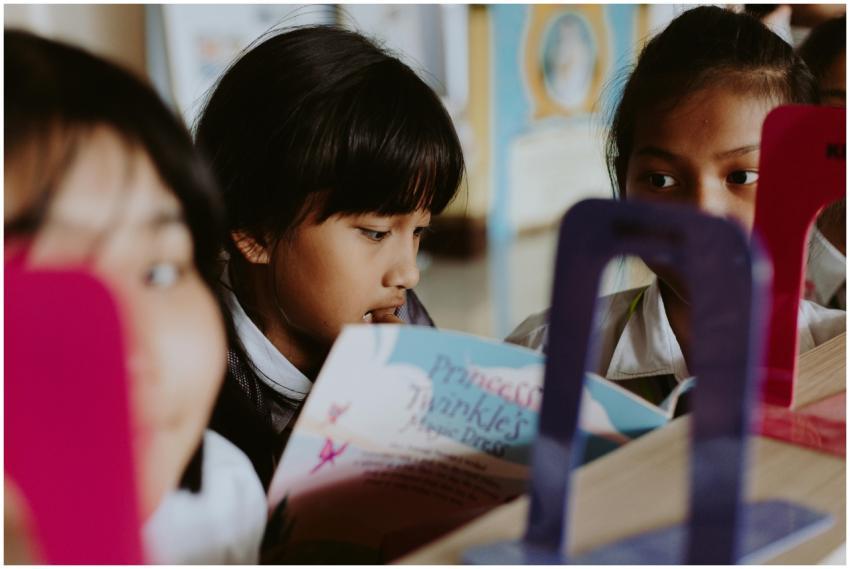 Group of children reading books together in a clas