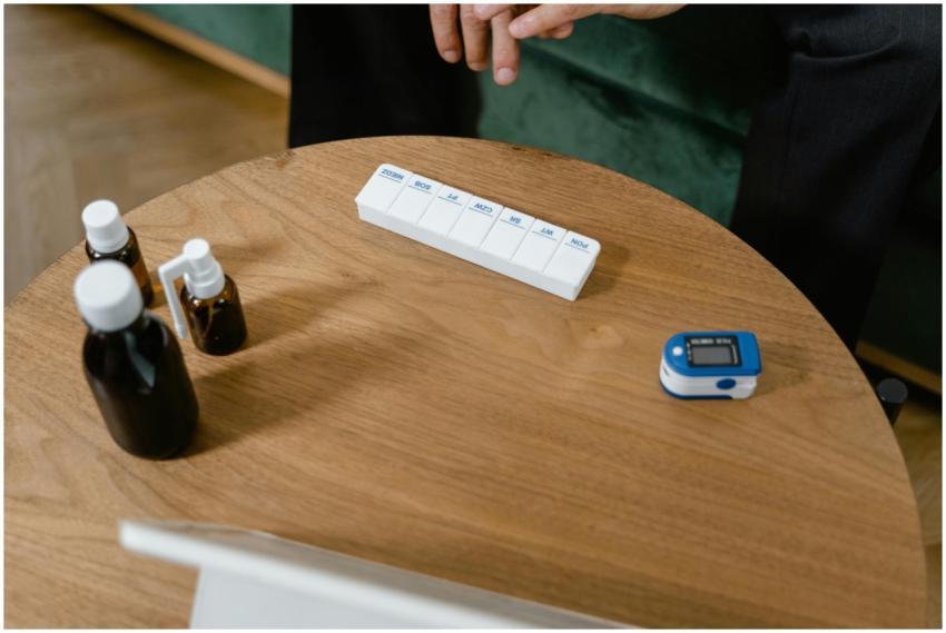 Pill organizer and medication bottles on a wooden