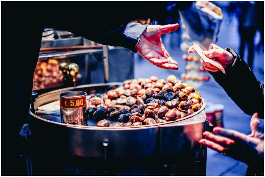 A street vendor selling roasted chestnuts to a cus