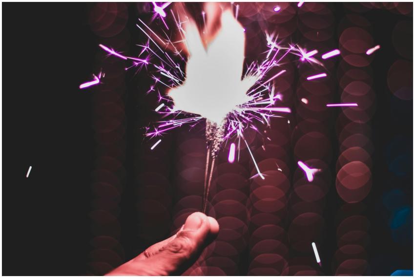 A close-up of a hand holding a sparkler with a vib