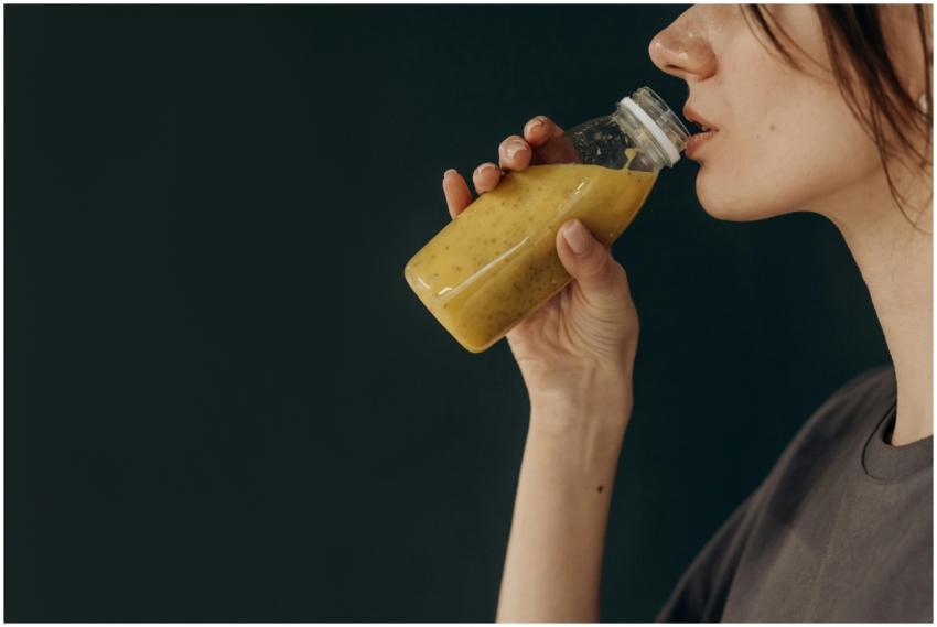 Side profile of a young woman sipping a nutritious