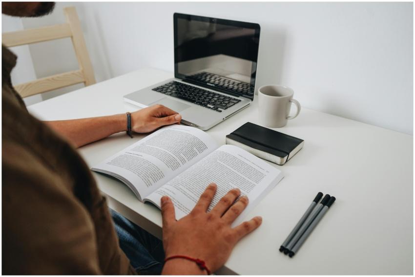 A person reading at a minimalist home office with