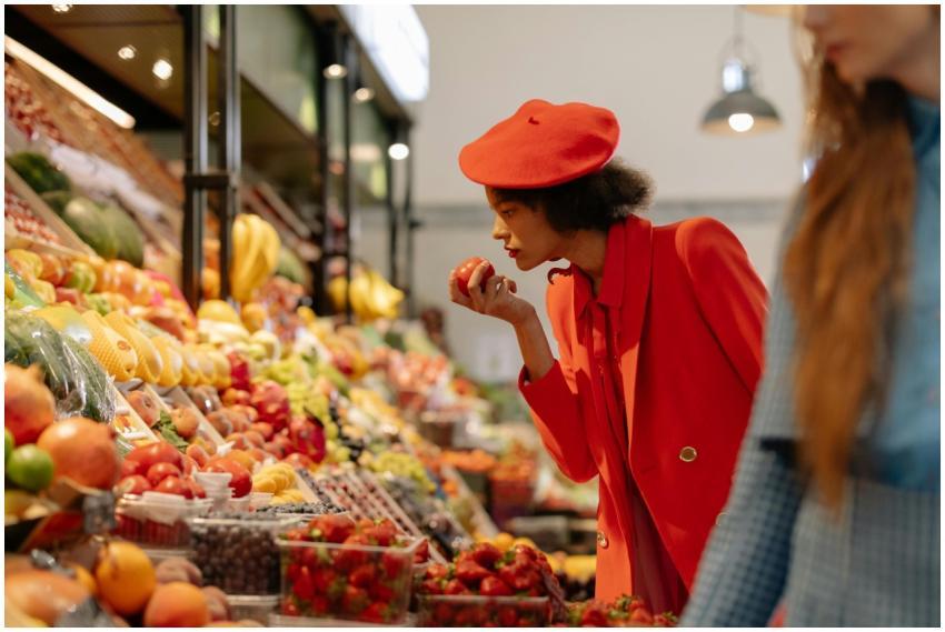Stylish woman in red outfit selecting fresh produc