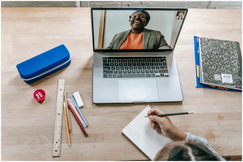 Top view of crop anonymous clever girl taking note