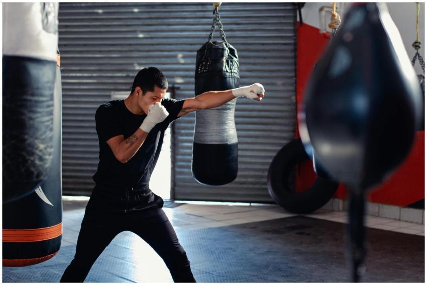 A man practicing punching techniques in a boxing g