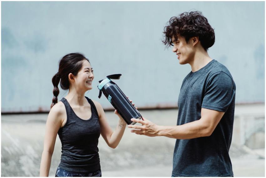 Smiling couple staying hydrated during outdoor sum