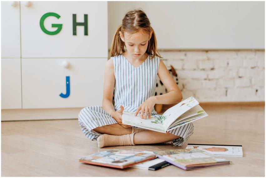 Young girl engrossed in reading books on the floor