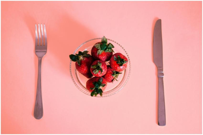 Bright strawberries in a bowl, laid out with silve