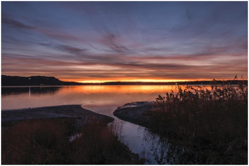 A tranquil lakeside scene at sunset with vibrant c