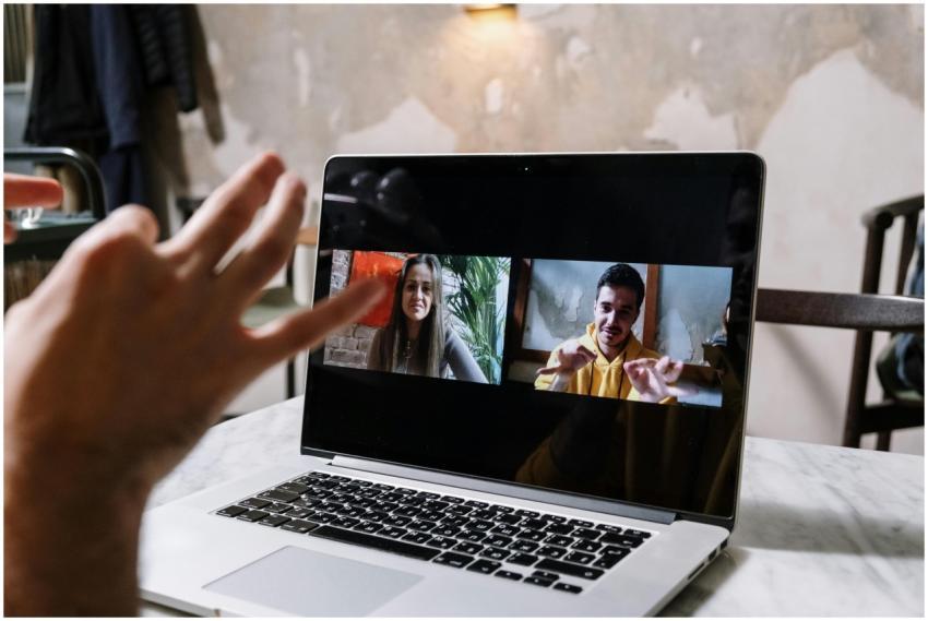 Hands gesturing during a video call on a laptop sc
