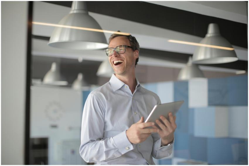 Cheerful businessman with eyeglasses holding table