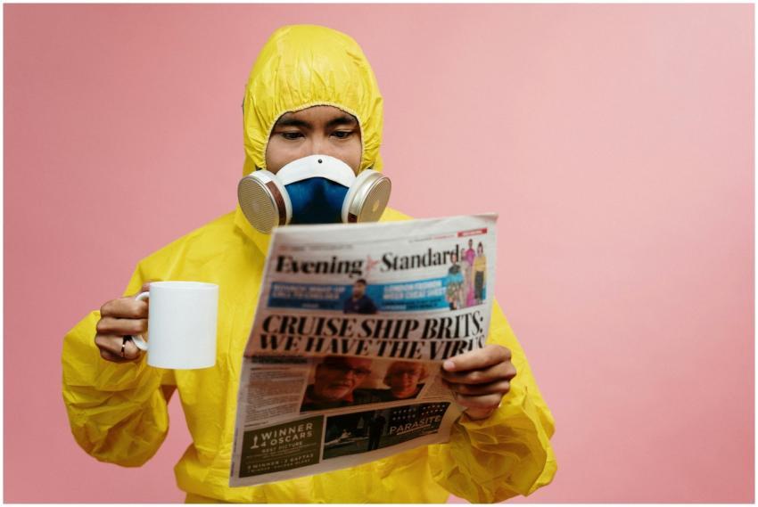 Person in yellow protective suit reading a newspap