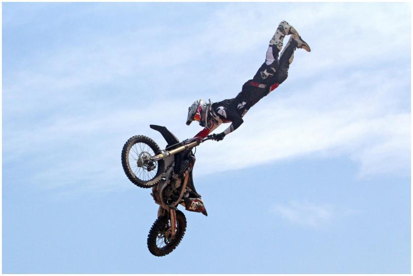 A motocross rider performs a daring freestyle stun
