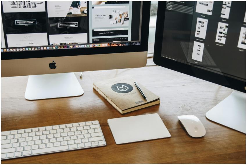 A minimalist desk setup featuring dual monitors, k