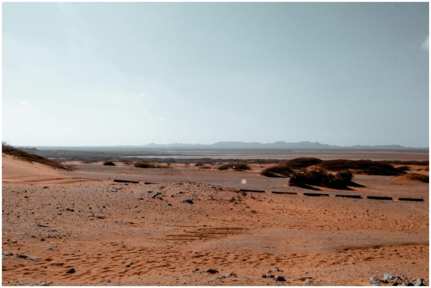 Vast desert landscape with sand dunes and clear bl
