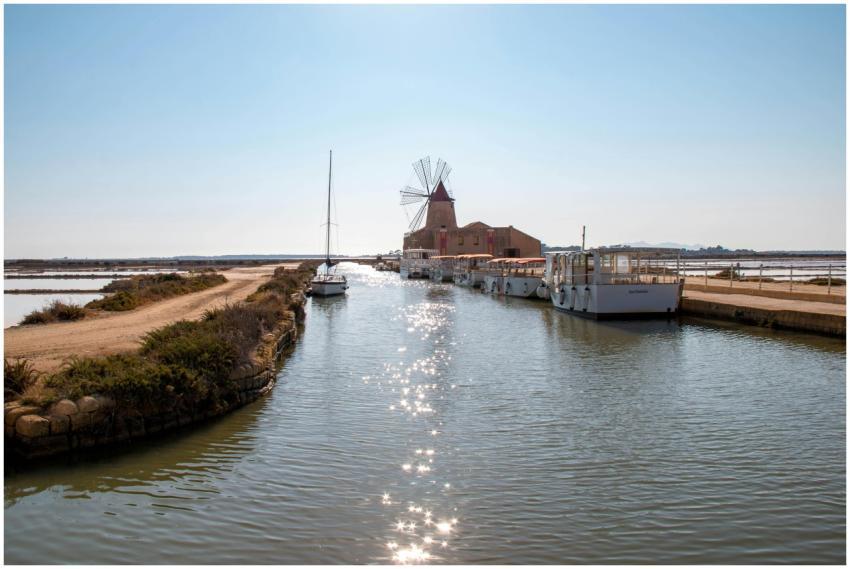 Scenic view of windmill and boats on a canal in Ma