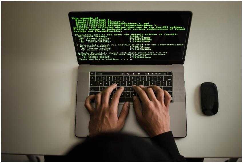 From above crop anonymous male programmer in black