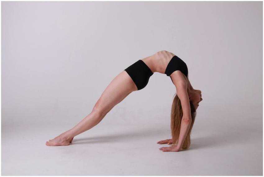 Woman in a bridge pose practicing yoga indoors, sh