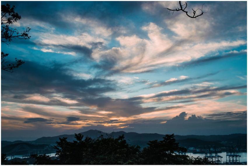 A dramatic sunset with vibrant clouds over a seren