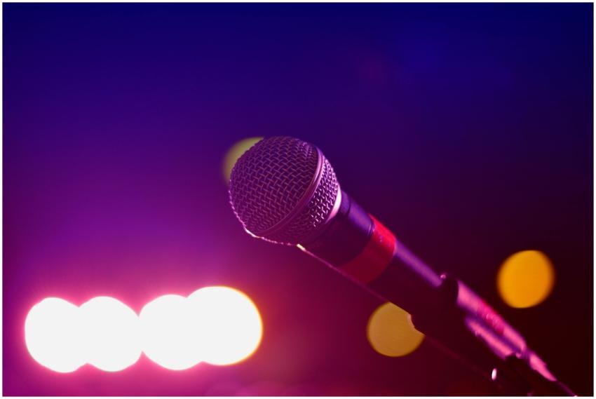 Colorful stage lighting highlights a microphone in