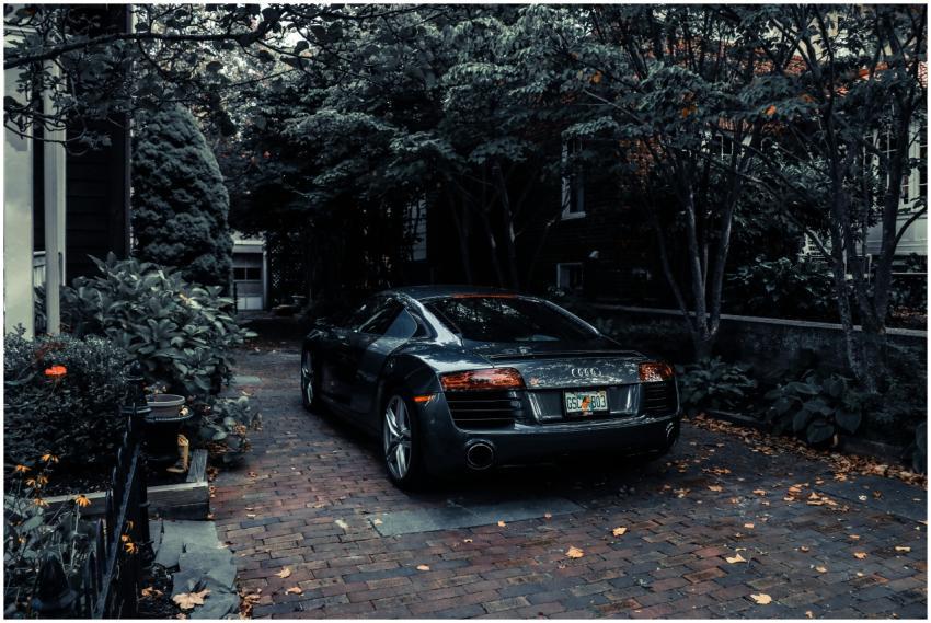 A sleek Audi R8 parked in a leafy residential driv