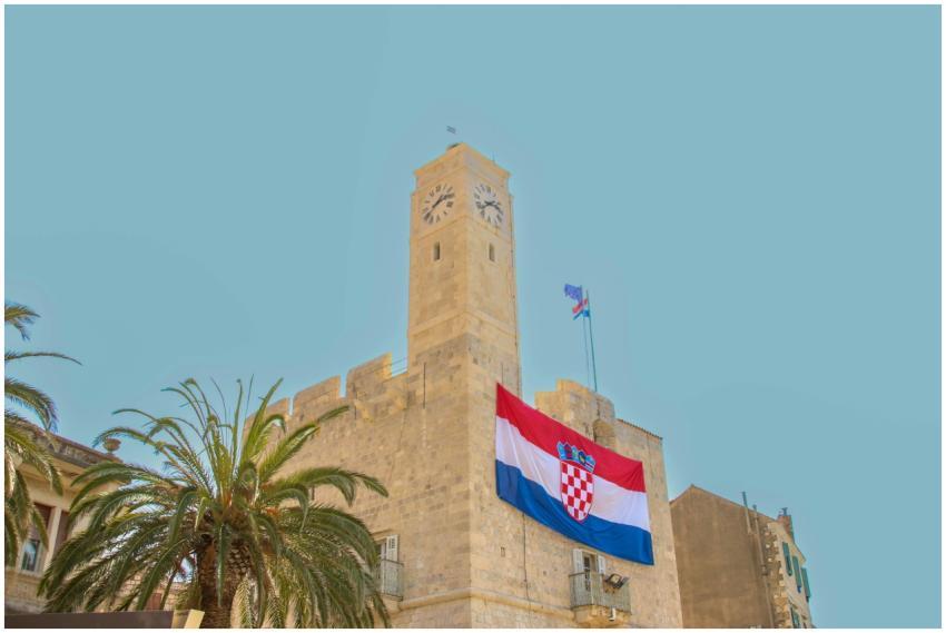 Stone clock tower adorned with Croatian flag under