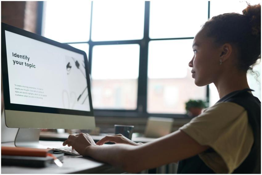 A woman attentively working on a computer in an of