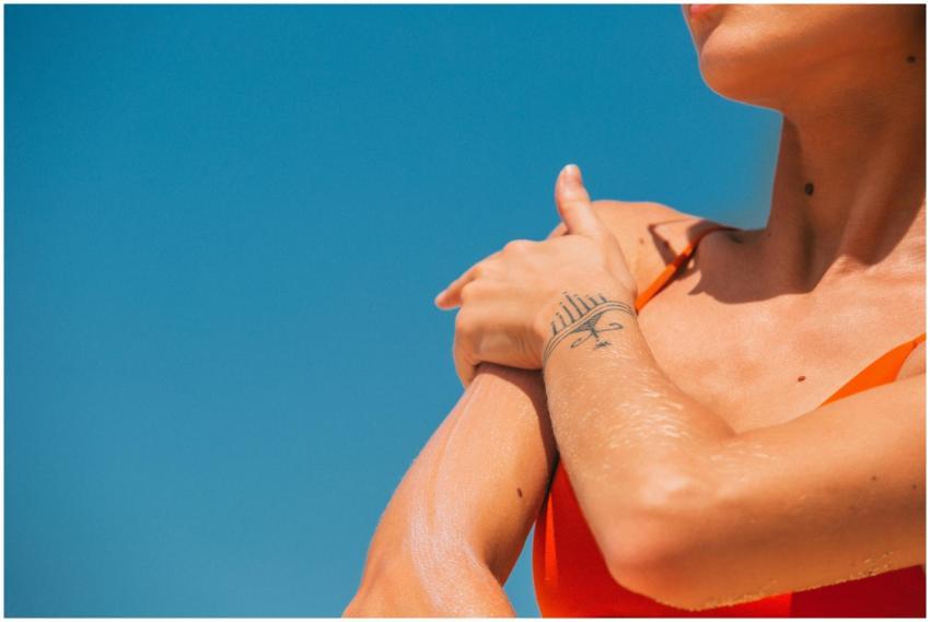 Close-up of a woman applying sunscreen to her shou