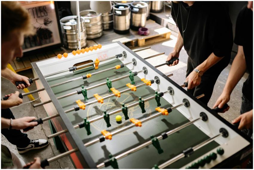 Energetic scene of people playing foosball indoors