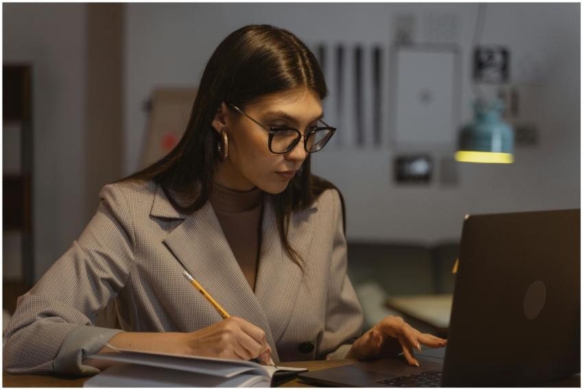 Confident businesswoman working on laptop and taki