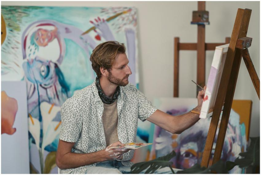 Caucasian male artist focusing on a colorful paint