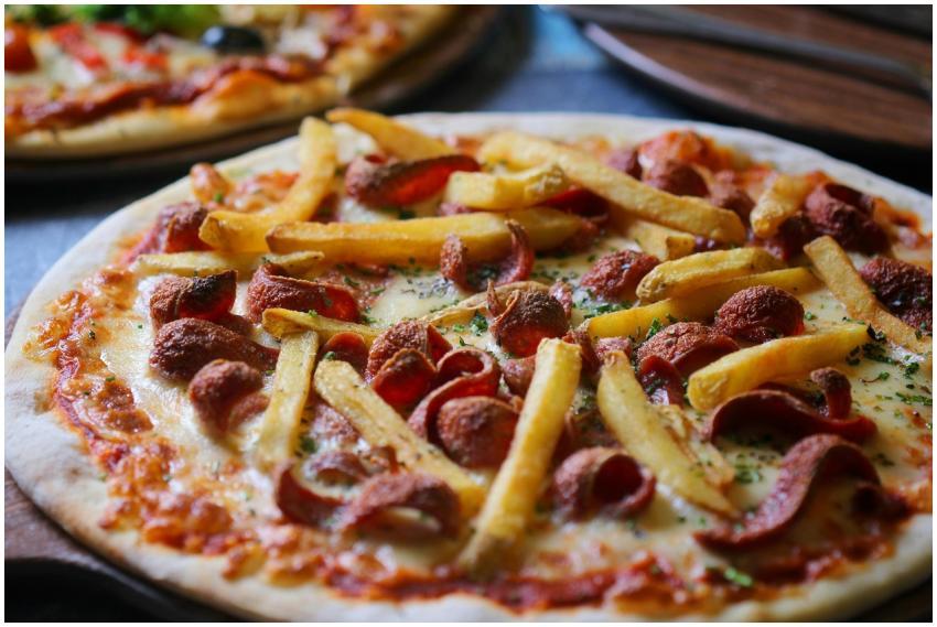 Close-up of a pepperoni and fries pizza, showcasin
