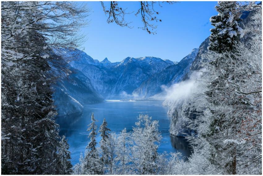 Serene winter landscape of a snowy lake surrounded