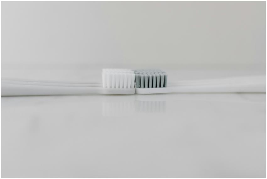Close-up of two toothbrushes head-to-head on a mar